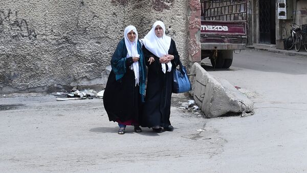 Женщины переходят дорогу в районе бывшего лагеря палестинских беженцев Ярмук в южном пригороде Дамаска - Sputnik Узбекистан