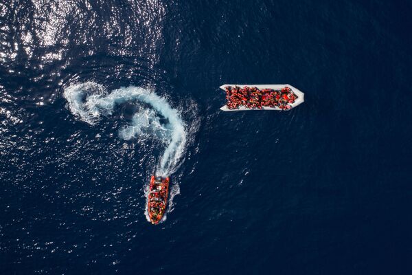 Беженцы и мигранты, спасенные испанской неправительственной организацией ProActiva Open Arms в водах недалеко от севера Ливии - Sputnik Узбекистан