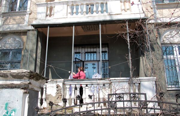 Центр города. Женщина развешивает белье на балконе старинной усадьбы. - Sputnik Узбекистан