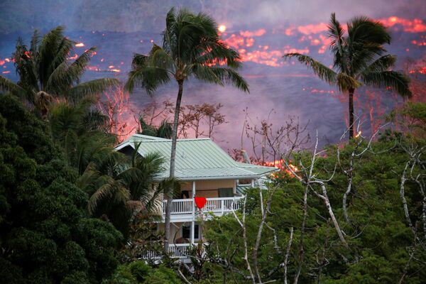 Лава возле дома на окраине Пахоа во время продолжающихся извержений вулкана Килауэа на Гавайях - Sputnik Узбекистан