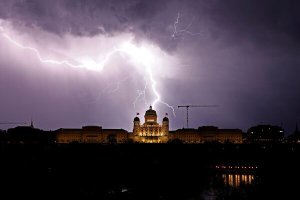 Сверкающие молнии над швейцарским федеральным дворцом в Берне, Швейцария - Sputnik Узбекистан