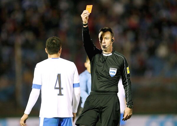 Судья показывает красную карточку игроку сборной Узбекистана Акрамжону Комилову в товащеском матче со сборной Уругвая - Sputnik Узбекистан