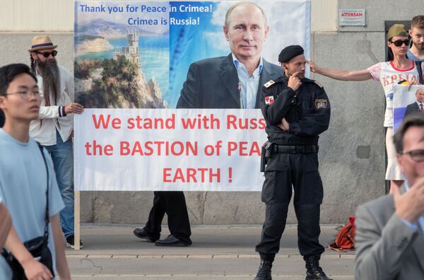 Жители Австрии держат плакат с изображением президента РФ Владимира Путина во время его встречи с федеральным президентом Австрийской Республики Александром Ван дер Белленом во дворце Хофбург в Вене - Sputnik Узбекистан