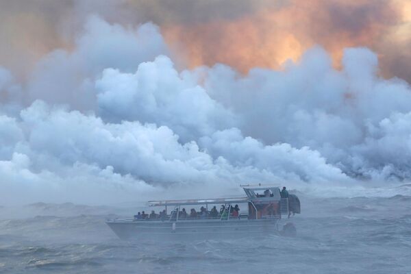 Люди наблюдают с прогулочного судна за тем, как лава из извергающегося вулкана Килауэа на Гавайях достигает Тихого океана - Sputnik Узбекистан