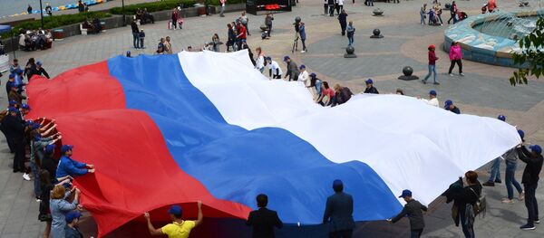 Люди держат флаг России - Sputnik Узбекистан