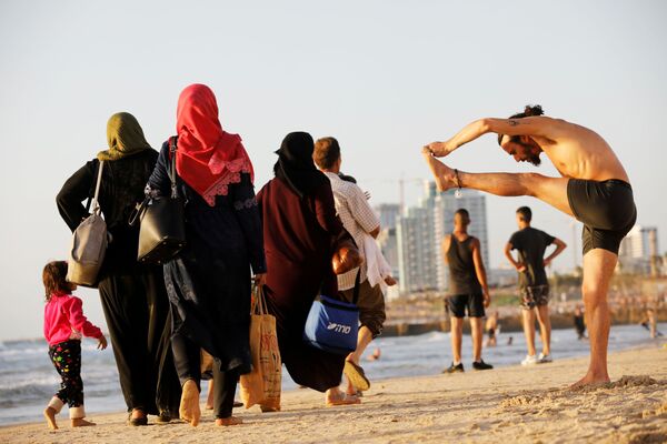Люди на побережье Средиземного моря во время мусульманского праздника Ураза-байрам на пляже в Тель-Авиве, Израиль - Sputnik Узбекистан