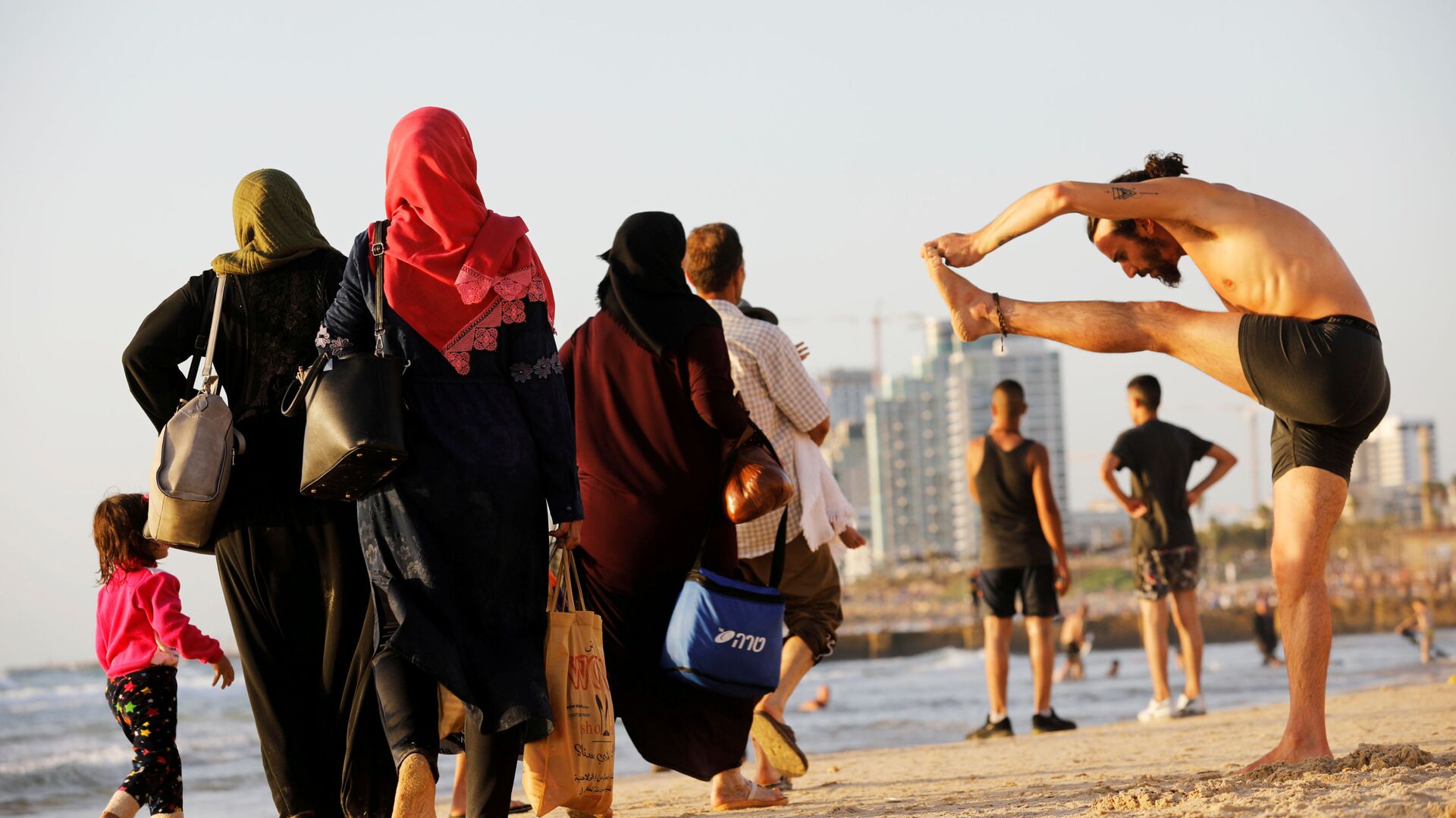 Люди на побережье Средиземного моря во время мусульманского праздника Ураза-байрам на пляже в Тель-Авиве, Израиль - Sputnik Узбекистан, 1920, 27.10.2021