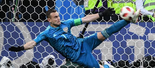 Вратарь Игорь Акинфеев (Россия) отбивает мяч в матче 1/8 финала чемпионата мира по футболу между сборными Испании и России - Sputnik Узбекистан