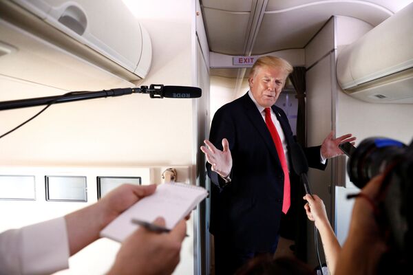 Президент США Дональд Трамп во время общения с журналистами на борту самолета - Sputnik Узбекистан