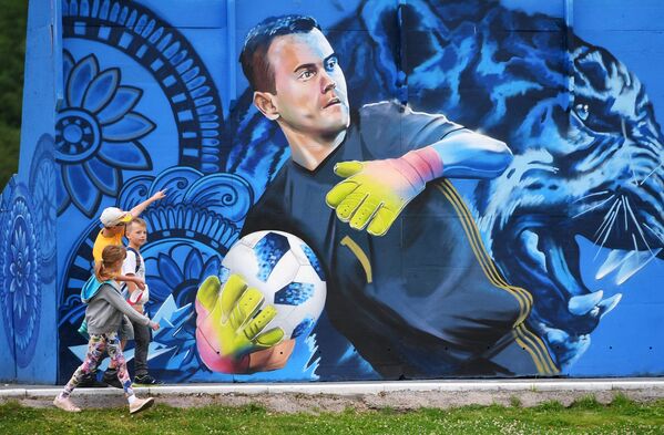 Дети рассматривают граффити с изображением вратаря сборной России по футболу Игоря Акинфеева в Щелково - Sputnik Узбекистан