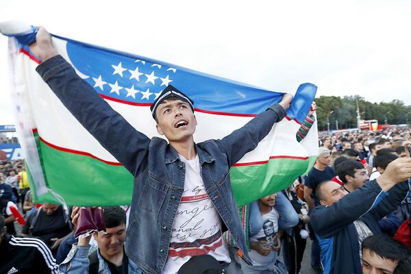 Болельщик с флагом Узбекистана в фан-зоне во время просмотра полуфинального матча ЧМ по футболу Франция-Бельгия  - Sputnik Узбекистан