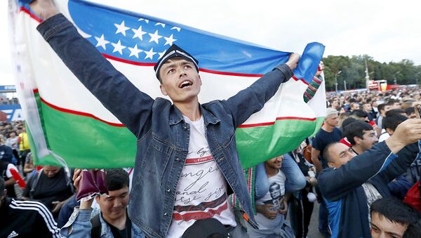 Болельщик с флагом Узбекистана в фан-зоне во время просмотра полуфинального матча ЧМ по футболу Франция - Бельгия  - Sputnik Узбекистан