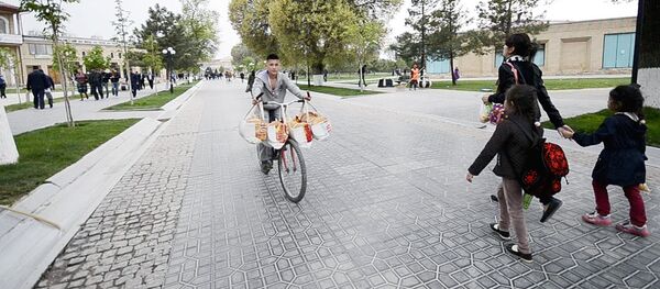 Молодой человек везет лепешки на велосипеде Молодой человек везет лепешки на велосипеде - Sputnik Узбекистан