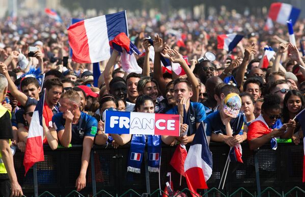 Футбольные болельщики в Париже радуются победе сборной Франции в финальном матче чемпионата мира по футболу против сборной Хорватии. - Sputnik Узбекистан