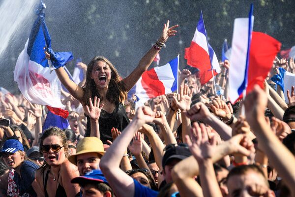 Футбольные болельщики радуются победе сборной Франции в финальном матче чемпионата мира по футболу против сборной Хорватии - Sputnik Узбекистан