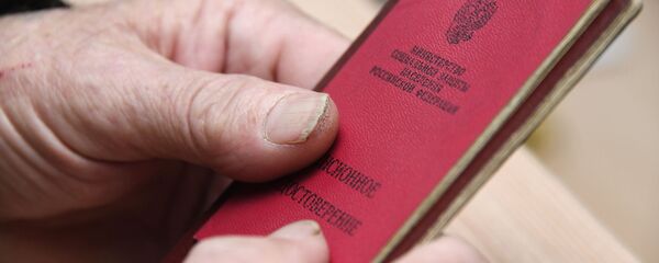 Мужчина демонстрирует пенсионное удостоверение Мужчина демонстрирует пенсионное удостоверение - Sputnik Ўзбекистон