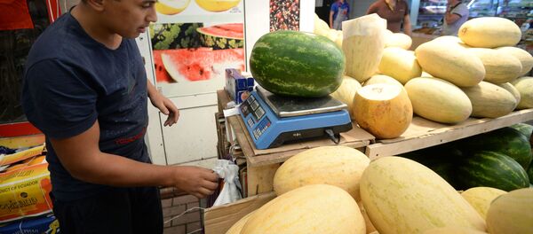 Продавец взвешивает арбуз Продавец взвешивает арбуз - Sputnik Ўзбекистон