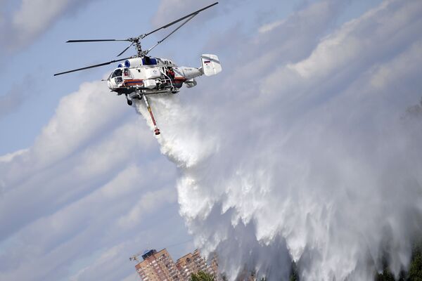 Пожарно-спасательный вертолет Ка-32А на показательном тушении пожара в рамках учений Департамента ГОЧСиПБ в честь Дня воздушного флота в Москве - Sputnik Узбекистан