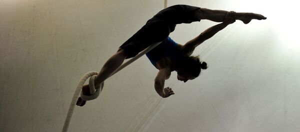 Девушка отрабатывает свою акробатическую программу на подвесной веревке Девушка отрабатывает свою акробатическую программу на подвесной веревке - Sputnik Узбекистан