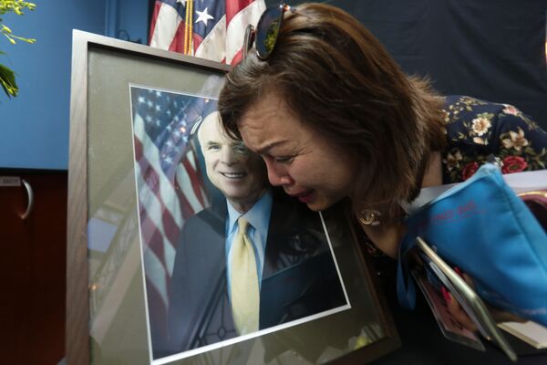 Женщина плачет у портрета сенатора Маккейна - Sputnik Узбекистан