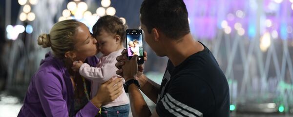 Молодая семья гуляет в парке на Дне независимости республики Молодая семья гуляет в парке на Дне независимости республики - Sputnik Ўзбекистон