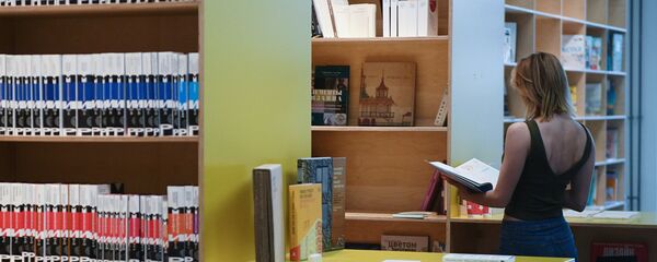 Девушка читает книгу в библиотеке - Sputnik Узбекистан