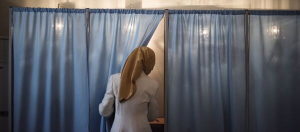 Женщина голосует на избирательном участке Женщина голосует на избирательном участке - Sputnik Ўзбекистон