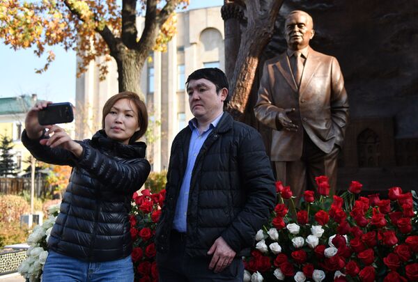 Молодые люди фотографируются у памятника первому президенту Узбекистана Исламу Каримову на улице Большая Полянка в Москве. - Sputnik Узбекистан