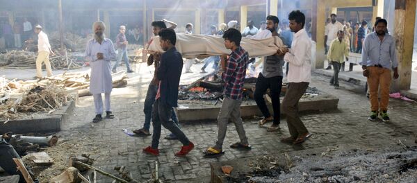 Тело жертвы пятничной железнодорожной аварии в Амритсаре, Индия перед кремацией  - Sputnik Узбекистан