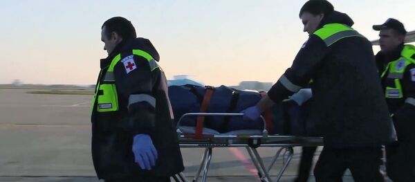 Сотрудники МЧС России везут на носилках одного из пострадавших при нападении на керченский колледж Сотрудники МЧС России везут на носилках одного из пострадавших при нападении на керченский колледж - Sputnik Узбекистан