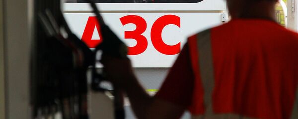 Заправщик возвращает заправочный пистолет в слот Заправщик возвращает заправочный пистолет в слот - Sputnik Ўзбекистон