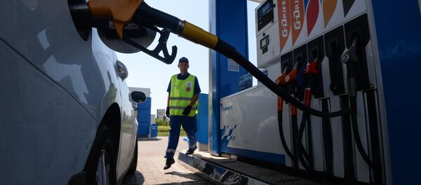 Сотрудник автозаправочной станции заправляет автомобиль клиента Сотрудник автозаправочной станции заправляет автомобиль клиента - Sputnik Ўзбекистон