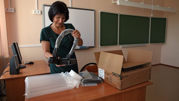 Учитель распаковывает прибор в одном из классов школы - Sputnik Узбекистан