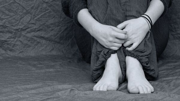 Женщина обнимает ноги. Иллюстративное фото - Sputnik Узбекистан