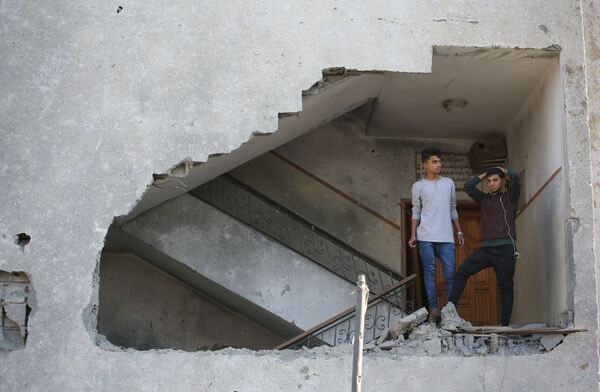 Молодые люди в жилом доме, пострадавшем от ракетного удара Израиля по территории сектора Газа.  - Sputnik Узбекистан